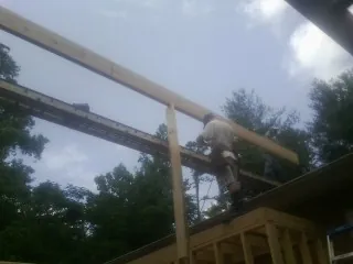 Carpenter setting a ridge beam over a new addition frame — Ice Dam Removal by Roofing Brothers in Wonder Lake