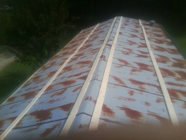 Rusted metal roof panels with new wood purlins before replacement — Storm Damage Roof Repair in Wonder Lake by Roofing Brothers