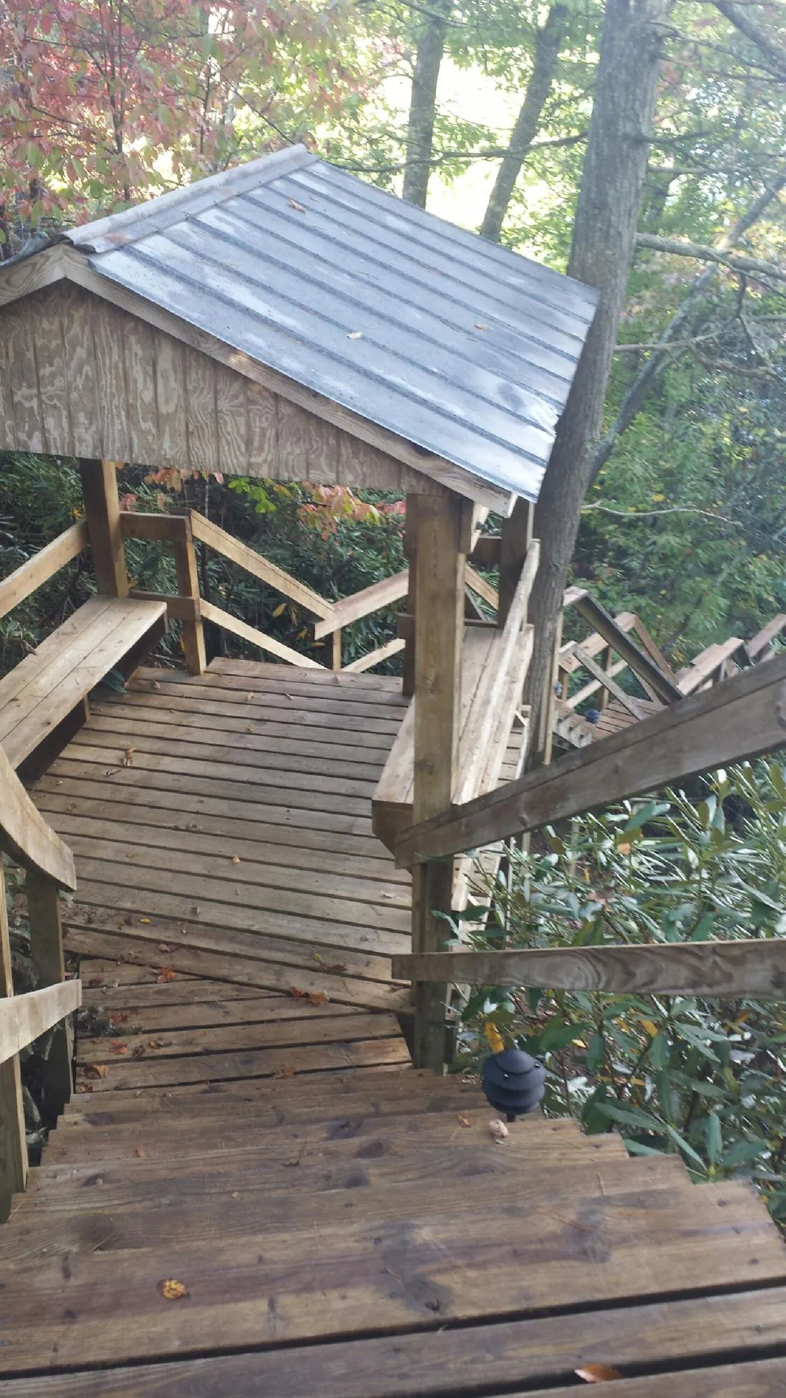 Metal roofed shelter over wooden steps on a wooded walkway — Skylight Repair & Installation work by our crew in Wonder Lake