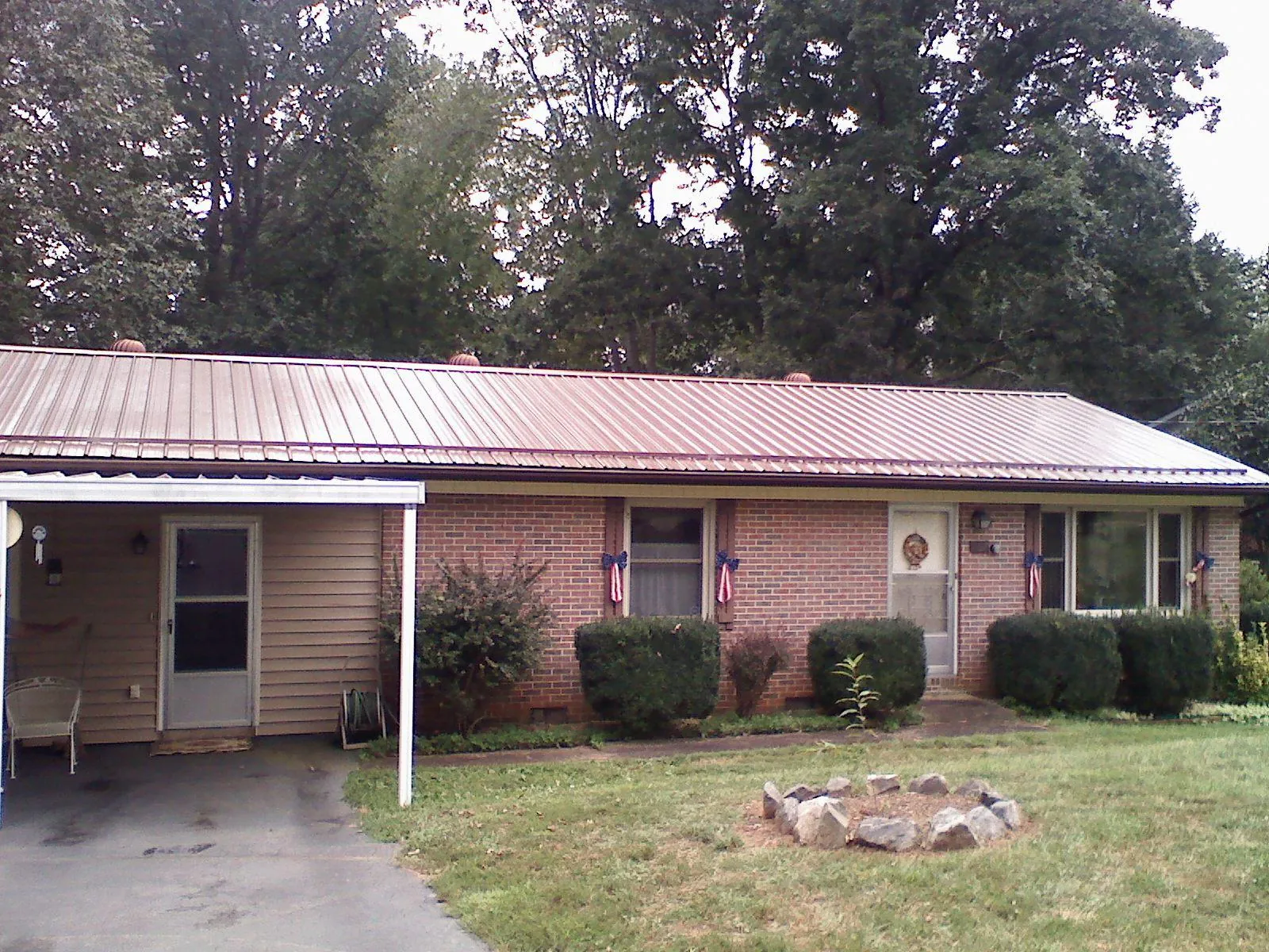 Bronze metal roof and carport on a brick ranch home — Roof Repair work by our crew in Wonder Lake